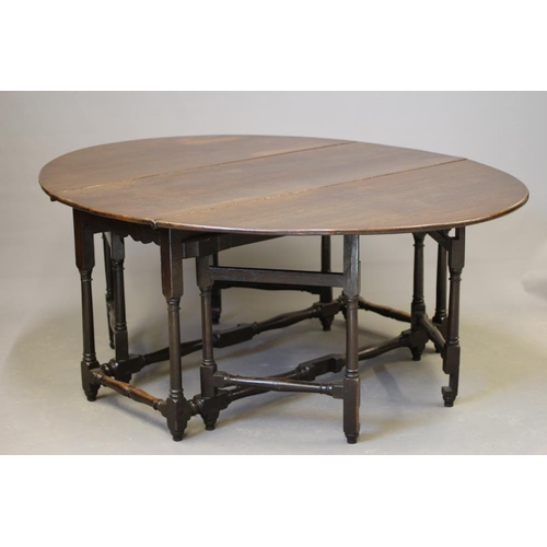 723 - AN OAK GATELEG DINING TABLE, early 18th century, the boarded top raised on columnar legs joined by b... 