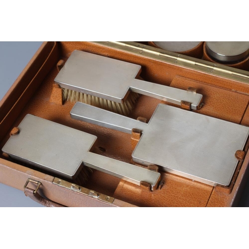 184 - AN ART DECO ELEVEN PIECE SILVER TRAVELLING DRESSING SET, maker's mark B & GH, Birmingham 1941, compr... 