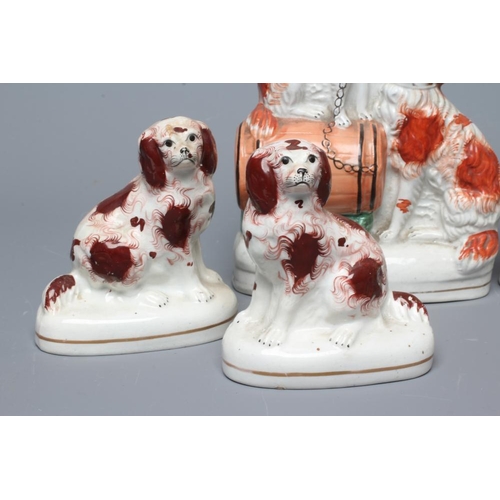 20 - A COLLECTION OF VICTORIAN POTTERY SPANIELS comprising a pair of spaniels with a barrel, 8