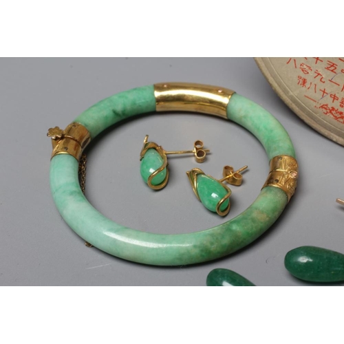 303 - A CHINESE POLISHED JADE STIFF HINGED BANGLE of cylindrical form the chased mounts stamped 14, by Lee... 