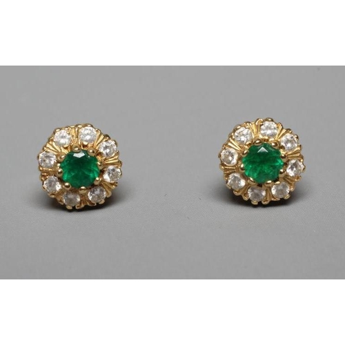 332 - A PAIR OF EMERALD AND DIAMOND CLUSTER EAR STUDS, the central facet cut emerald claw set to a border ... 