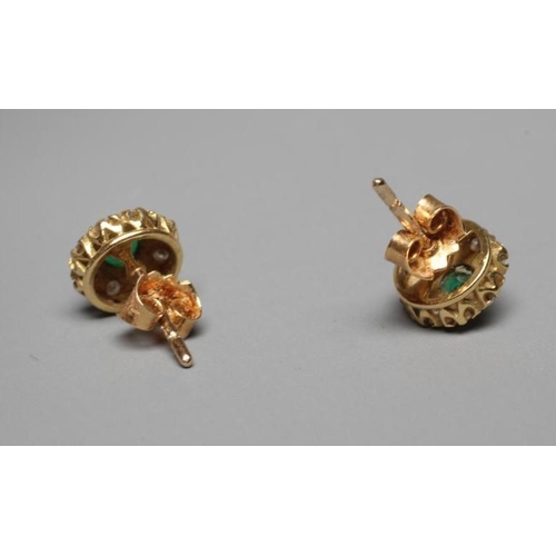 332 - A PAIR OF EMERALD AND DIAMOND CLUSTER EAR STUDS, the central facet cut emerald claw set to a border ... 