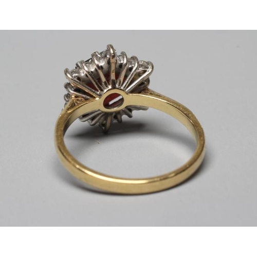 357 - A GARNET AND DIAMOND CLUSTER RING, the central hexagonal cut garnet claw set to a border of eighteen... 