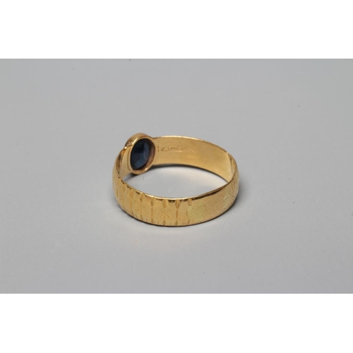 362 - A SOLITAIRE SAPPHIRE RING, the oval facet cut stone in rub-over setting to a star and line cut 22ct ... 