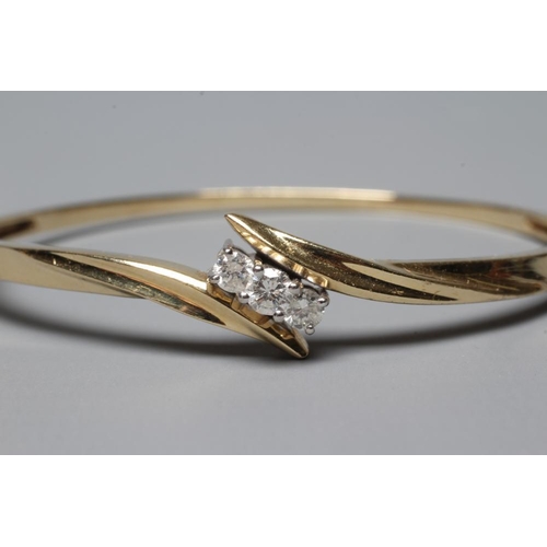 364 - A DIAMOND STIFF HINGED BANGLE, the upper section with three brilliant cut stones in an open crossove... 