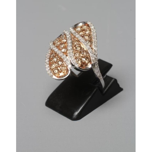 377 - A DIAMOND COCKTAIL RING, the four coma shaped panels centred by small champagne coloured stones to a... 