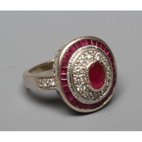 380 - A RUBY AND DIAMOND TARGET PLAQUE RING, the oval cut ruby of approximately 1ct collet set to a border... 