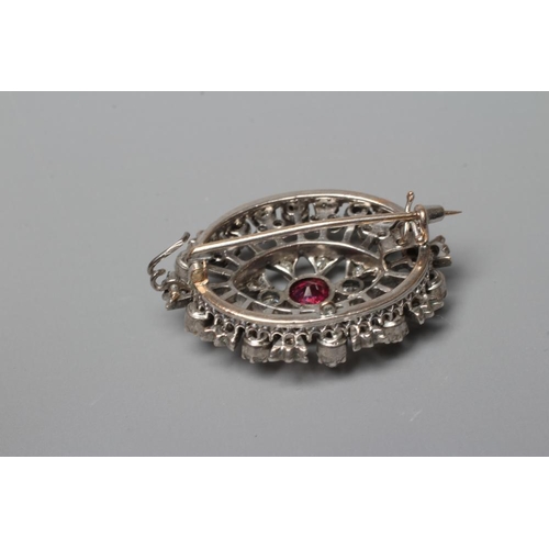 396 - A RUBY AND DIAMOND BROOCH, the central circular facet cut ruby claw set to open borders of old mix c... 