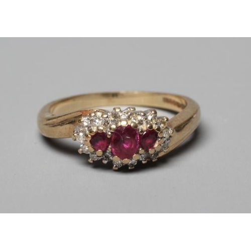 401 - A RUBY AND DIAMOND CROSSOVER RING, the three graduated rubies claw set to a border of small brillian... 