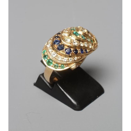 405 - A MULTI-GEM COCKTAIL RING, the oval panelled boss set with rows of diamonds, emeralds and sapphires ... 