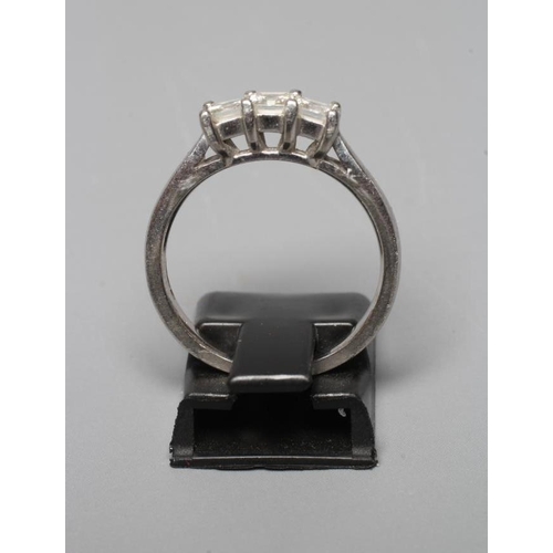 407 - A THREE STONE DIAMOND RING, the Princess cut stones point set to a plain platinum shank, sponsor Hoc... 