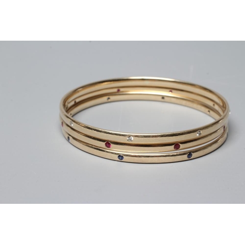 408 - A MATCHED SET OF THREE STONE SET 9CT GOLD BANGLES, set with either eight diamonds, rubies or sapphir... 