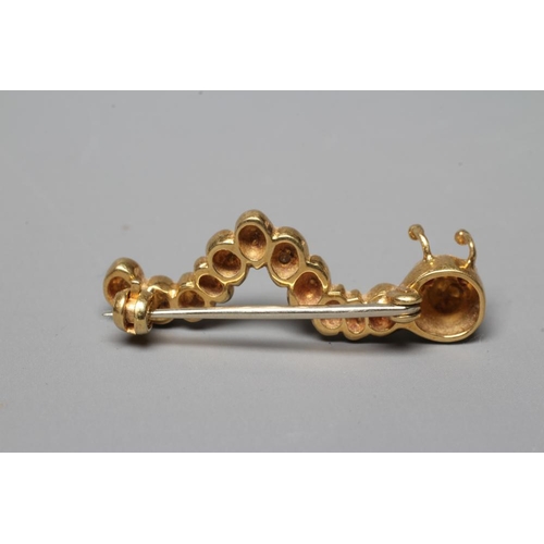 409 - AN 18CT GOLD NOVELTY CATERPILLAR BROOCH set with two facet cut ruby eyes and with six pairs of brill... 