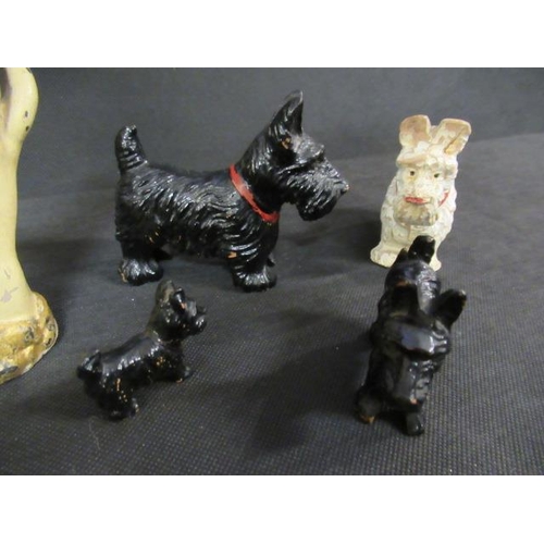 6 - FOUR PAINTED WOOD SCOTTY DOGS AND A METAL HAND PAPERWEIGHT