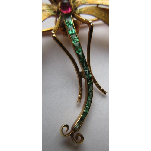 319 - A DRAGONFLY BROOCH with engraved wings, facet cut ruby eyes and cabochon thorax, and channel set gra... 