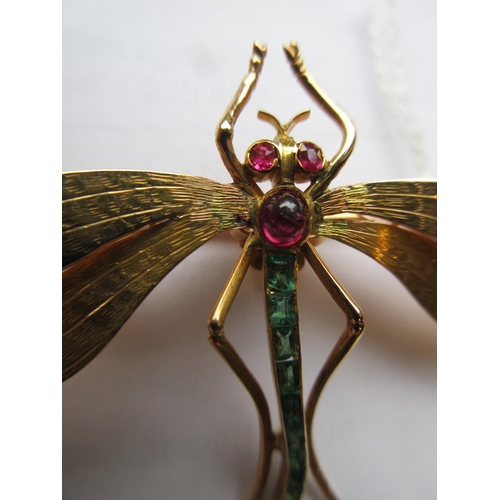 319 - A DRAGONFLY BROOCH with engraved wings, facet cut ruby eyes and cabochon thorax, and channel set gra... 