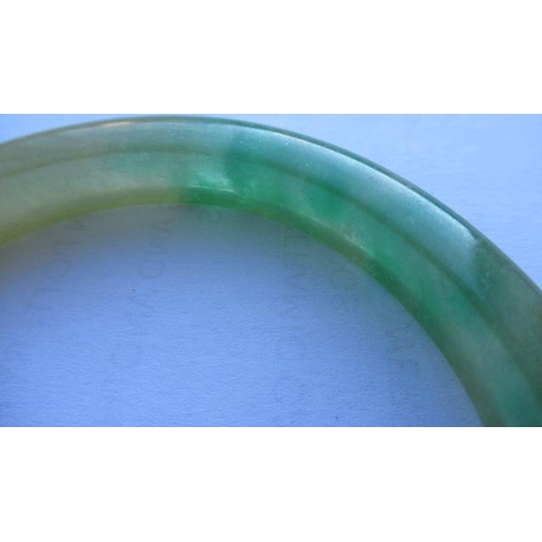 304 - A CHINESE POLISHED JADE BANGLE of D form, 37g, together with a silver mounted jade Shou pendant, sta... 