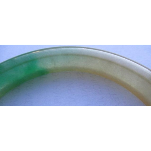 304 - A CHINESE POLISHED JADE BANGLE of D form, 37g, together with a silver mounted jade Shou pendant, sta... 