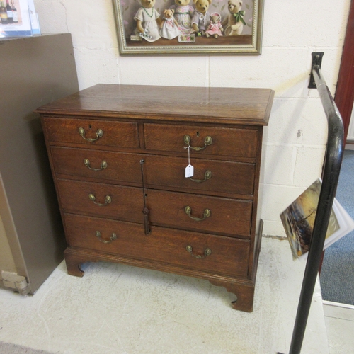 670 - A GEORGIAN OAK STRAIGHT FRONT CHEST, early 19th century, the moulded edged top over two short and th... 