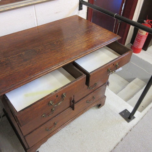 670 - A GEORGIAN OAK STRAIGHT FRONT CHEST, early 19th century, the moulded edged top over two short and th... 