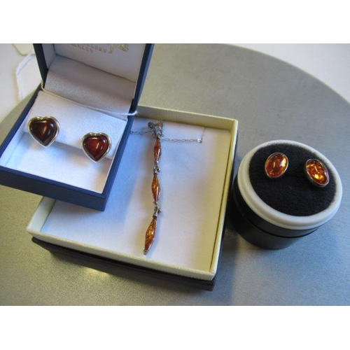 150 - AMBER SET SILVER PENDANT AND TWO PAIRS OF EARRINGS