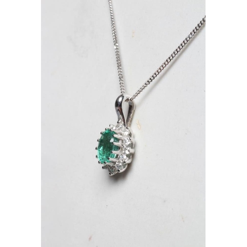 220 - AN EMERALD AND DIAMOND CLUSTER PENDANT, the oval facet cut emerald claw set to a border of twelve sm... 