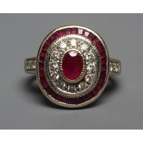 224 - A RUBY AND DIAMOND TARGET PLAQUE RING, the oval cut ruby of approximately 1ct, collet set to a borde... 