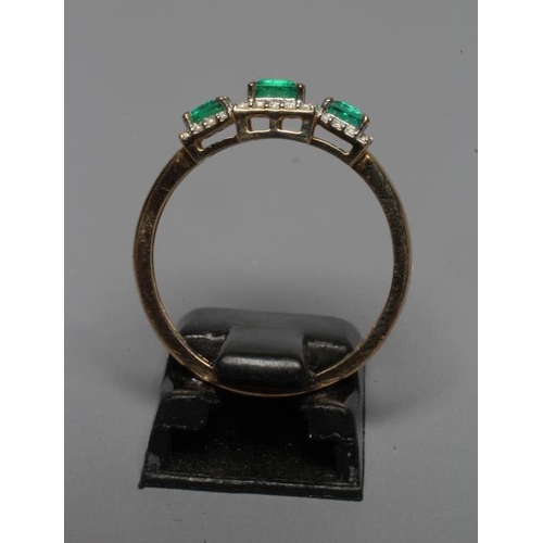 229 - AN EMERALD AND DIAMOND TRIPLE CLUSTER RING, the three square cut emeralds claw set to borders of sma... 