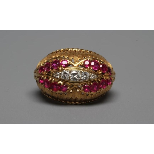 232 - A RUBY AND DIAMOND COCKTAIL RING, the high oval boss shaped panel centred by an elipse claw set with... 