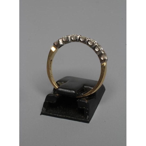 234 - A SEVEN STONE DIAMOND HALF HOOP ETERNITY RING, the brilliant cut stones claw set to a plain 18ct gol... 