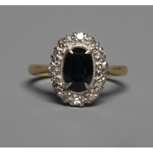 236 - A SAPPHIRE AND DIAMOND CLUSTER RING, the oval facet cut sapphire claw set to a border of point set s... 