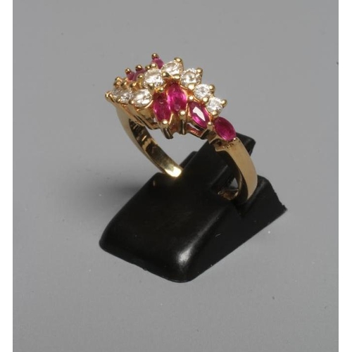 238 - A RUBY AND DIAMOND CROSSOVER RING claw set with eight marquise cut rubies to graduated brilliant cut... 