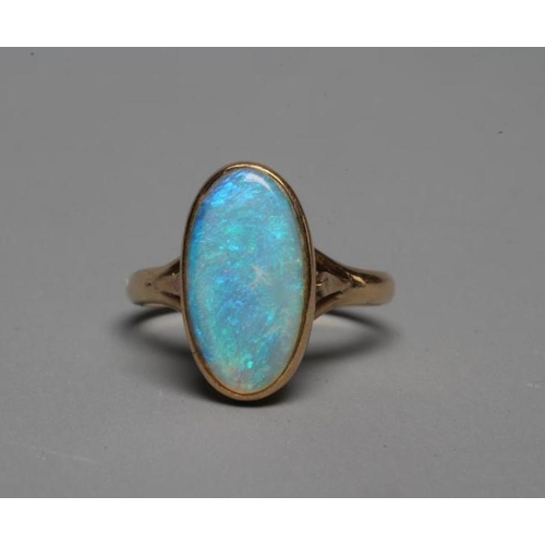 246 - AN OPAL DRESS RING, the oval cabochon polished stone collet set to a plain shank stamped 14k, WK, si... 