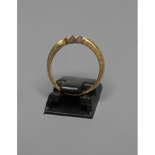 264 - A THREE STONE DIAMOND RING, the marquise cut stones claw set to open shoulders and a plain 18ct gold... 