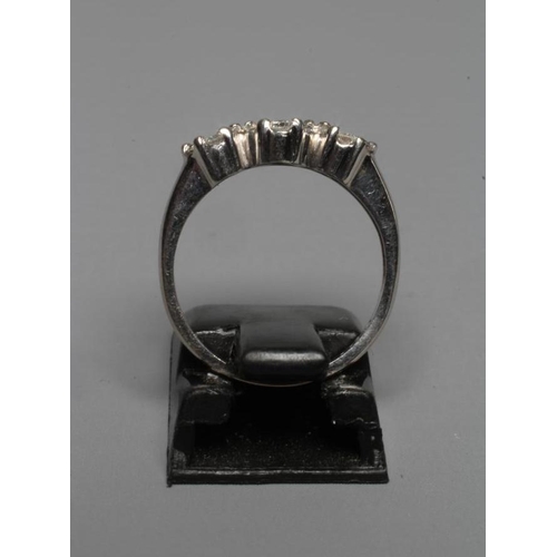 286 - A DIAMOND TRIPLE CLUSTER RING, the brilliant cut stones claw set to plain shoulders and a white shan... 