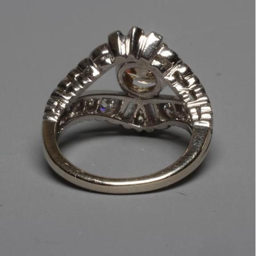 289 - A DIAMOND DRESS RING, the central cinnamon stone of approximately 1.2cts claw set to baguette and ma... 