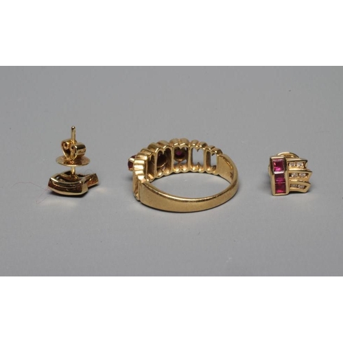 292 - A THREE STONE RUBY RING, the round cut stones claw set to open oblong panels with similar open shoul... 