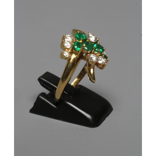 294 - AN EMERALD AND DIAMOND ABSTRACT CLUSTER RING, the five graduating emeralds claw set with ten round b... 