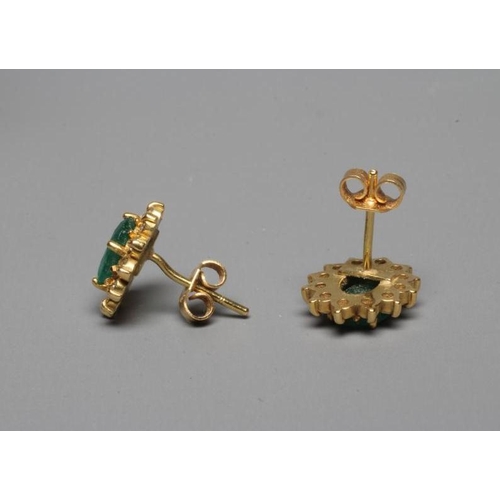 306 - A PAIR OF EMERALD AND DIAMOND CLUSTER EAR STUDS, the oval facet cut emeralds each claw set to a bord... 