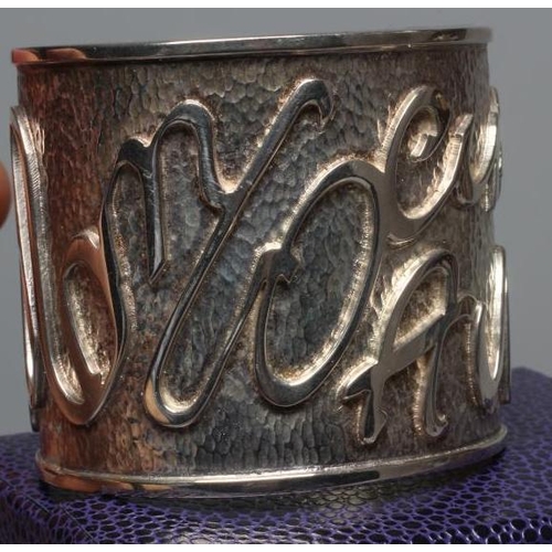 314 - A MODERN WIDE SILVER CUFF by Hamilton & Inches, Edinburgh 2002, cast in low relief with 'Mon Coeur A... 