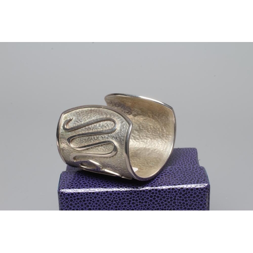 315 - A MODERN WIDE SILVER CUFF by Hamilton & Inches, Edinburgh 2002, cast in low relief with 'Mon Coeur A... 