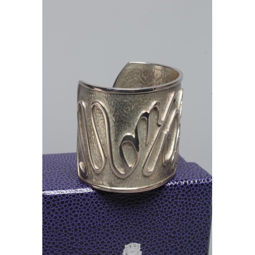 315 - A MODERN WIDE SILVER CUFF by Hamilton & Inches, Edinburgh 2002, cast in low relief with 'Mon Coeur A... 