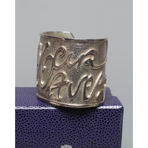 315 - A MODERN WIDE SILVER CUFF by Hamilton & Inches, Edinburgh 2002, cast in low relief with 'Mon Coeur A... 