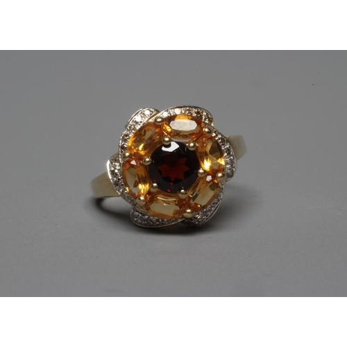 323 - A MULTI-GEM COCKTAIL RING centred by a circular facet cut garnet within a border of six oval facet c... 