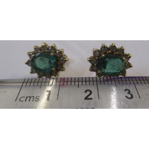 306 - A PAIR OF EMERALD AND DIAMOND CLUSTER EAR STUDS, the oval facet cut emeralds each claw set to a bord... 