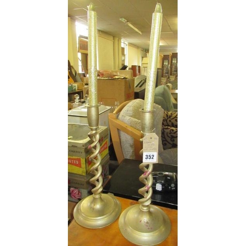 352 - TWO BRASS CANDLESTICKS WITH CANDLES