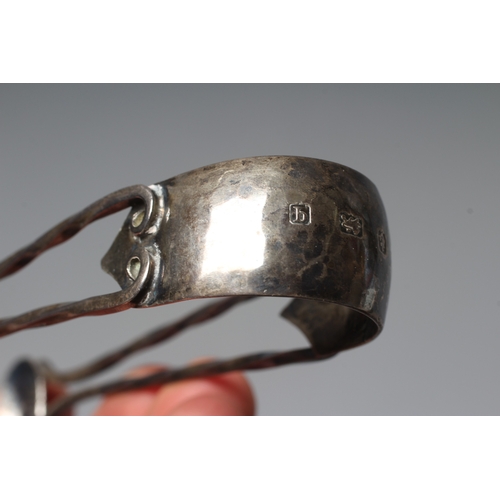 105 - A PAIR OF GEORGE V SILVER ARTS AND CRAFTS SUGAR TONGS by A E Jones, Birmingham 1915, the oval bowls ... 