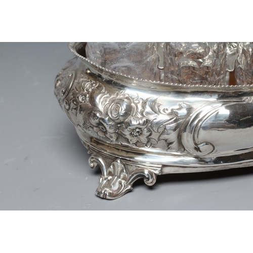 144 - A VICTORIAN SILVER SIX BOTTLE CRUET by Thomas Smily, London 1858, of oval bombe form chased with flo... 