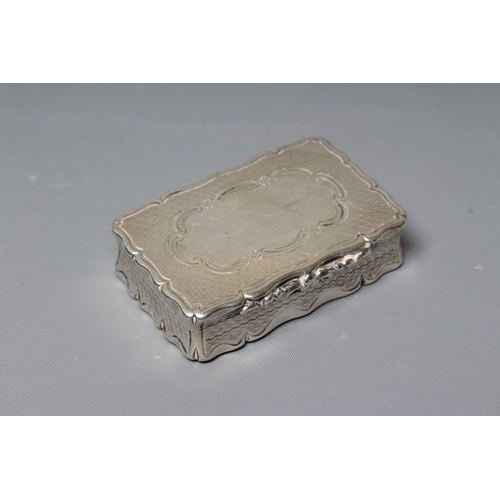 150 - AN EARLY VICTORIAN SILVER SNUFF BOX by George Unite, Birmingham 1854, of shaped oblong form with wav... 