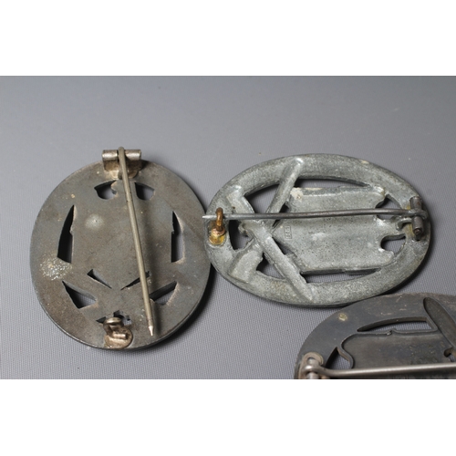 403 - THREE GERMAN THIRD REICH ASSAULT BADGES, comprising one by JFS with inset mounting for the pin and h... 